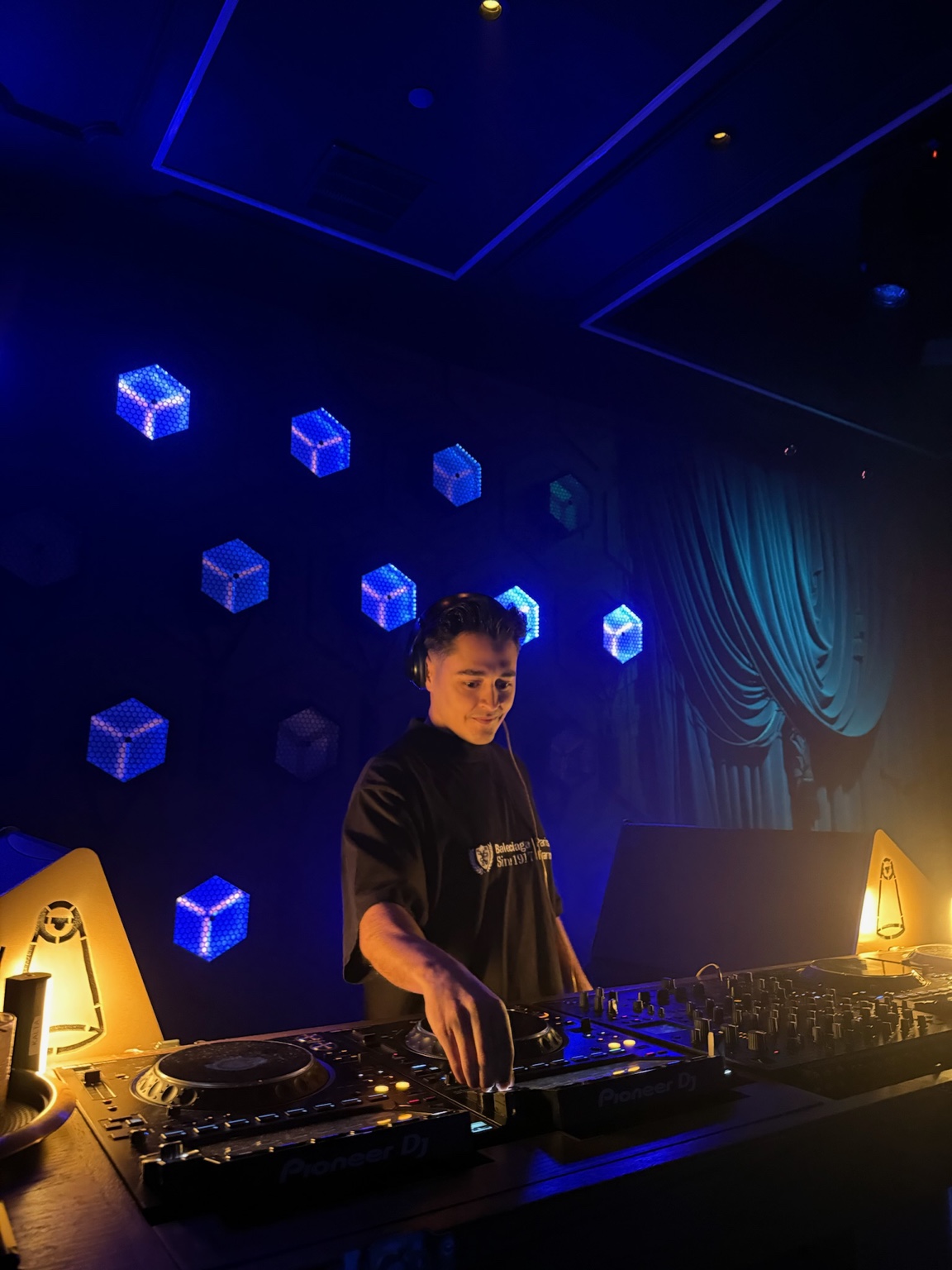 Panos DJing beneath blue cube lights