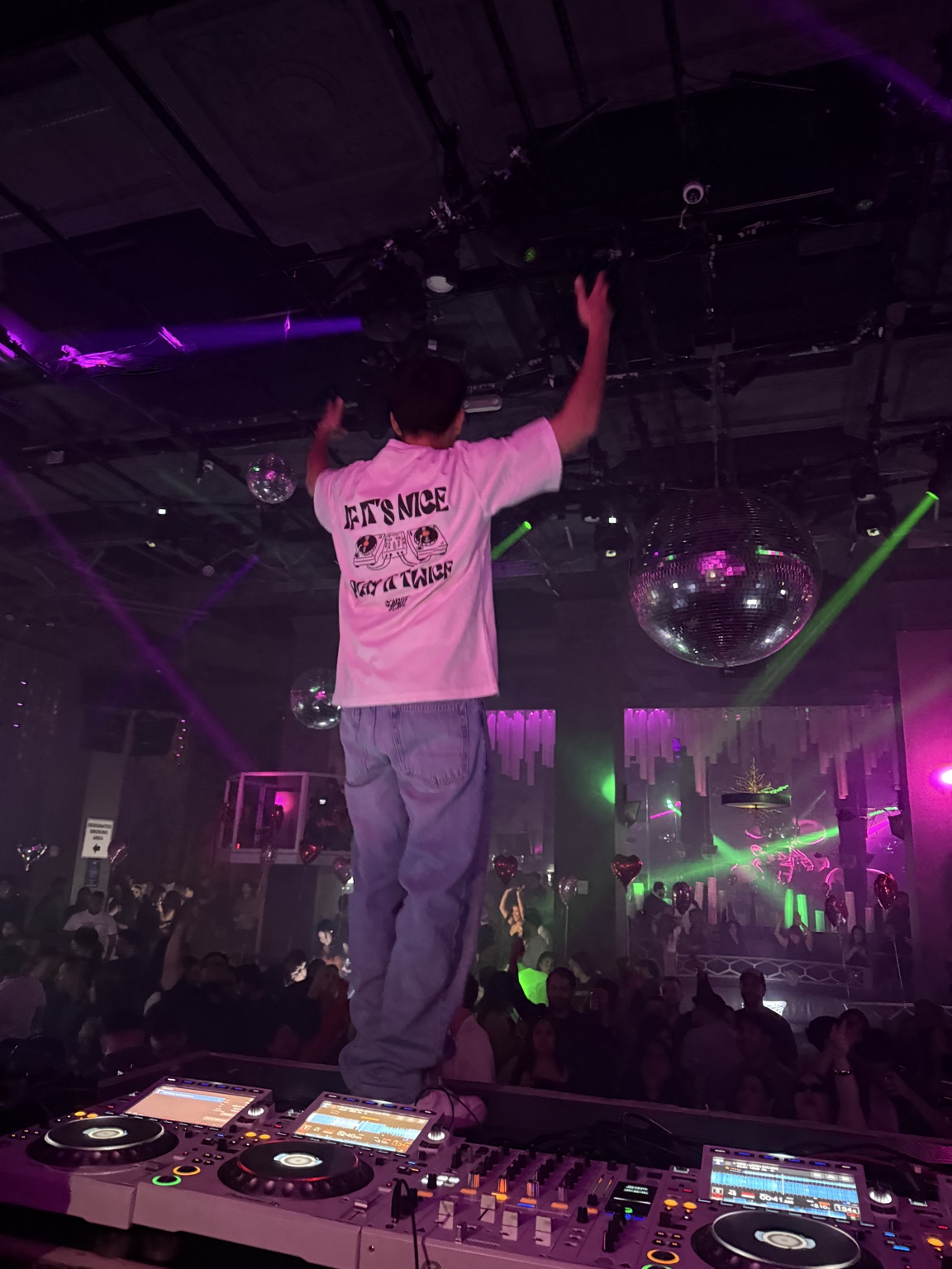 Panos performing on a club stage under purple lights